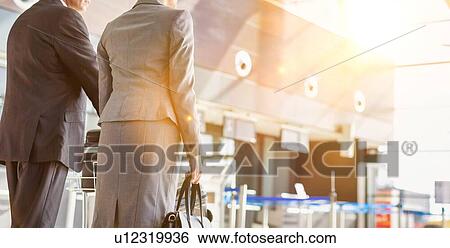 Stock Photograph - Business people checking their bags in airport. Fotosearch