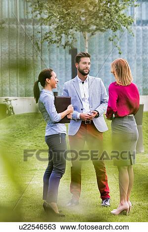 Stock Image - Business people discussing plans on meeting outdoor. Fotosearch
