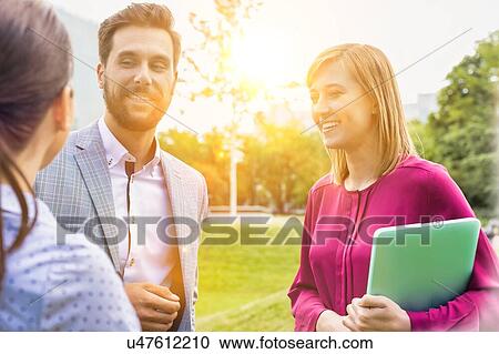 Stock Image - Business people discussing plans on meeting outdoor. Fotosearch