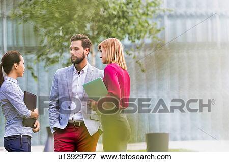 Stock Photo - Business people discussing plans on meeting outdoor. Fotosearch