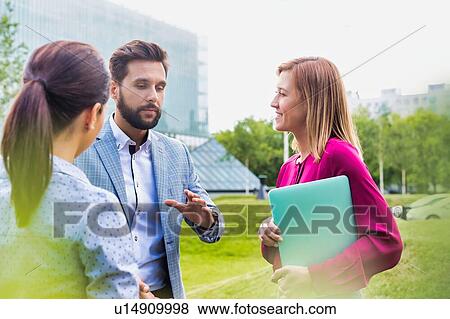 Stock Photo - Business people discussing plans on meeting outdoor. Fotosearch