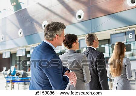 Stock Image - Business people queueing for check in at airport. Fotosearch