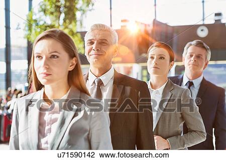 Stock Image - Business people queueing for check in airport. Fotosearch