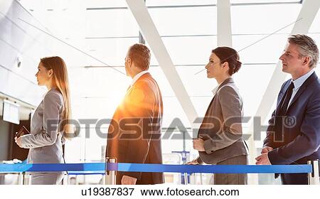 Business people queueing for check in at airport View Large Photo Image Stock Photo - Business people queueing for check in at airport. Fotosearch