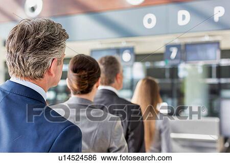 Stock Photograph - Business people queueing for check in at airport. Fotosearch