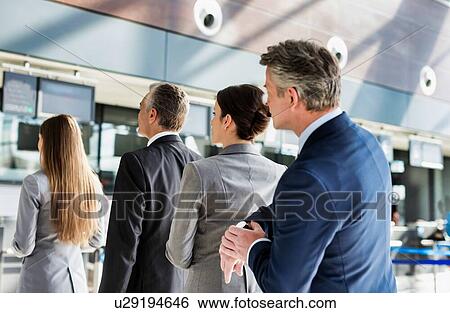 Stock Photograph - Business people queueing for check in at airport. Fotosearch