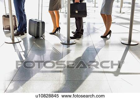 Stock Photography - Business people queueing for check in at airport. Fotosearch