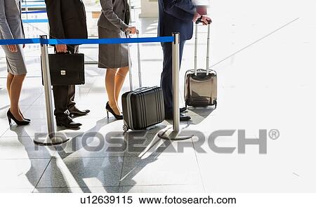 Stock Photography - Business people queueing for check in airport. Fotosearch