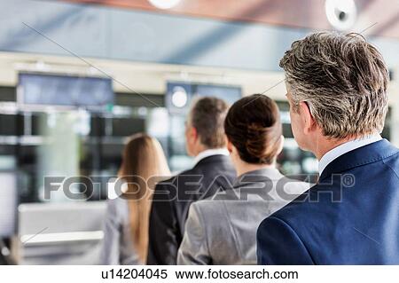 Stock Photography - Business people queueing for check in at airport. Fotosearch