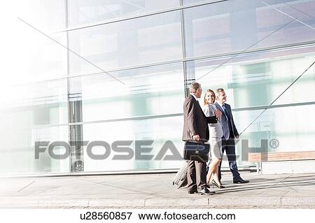 Business people walking while talking in airport View Large Photo Image Stock Photo - Business people walking while talking in airport . Fotosearch