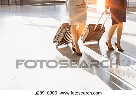 Business people walking with their suitcase in airport View Large Photo Image Stock Image - Business people walking with their suitcase in airport. Fotosearch