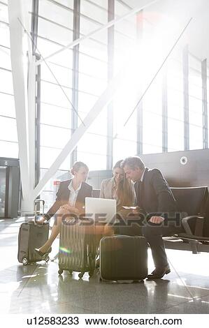 Business people working while waiting for boarding in the airport View Large Photo Image Stock Image - Business people working while waiting for boarding in the airport. Fotosearch