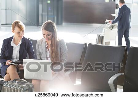 Business people working while waiting for boarding in the airport View Large Photo Image Stock Photo - Business people working while waiting for boarding in the airport. Fotosearch