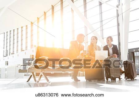 Stock Photograph - Business people working while waiting for boarding in the airport. Fotosearch