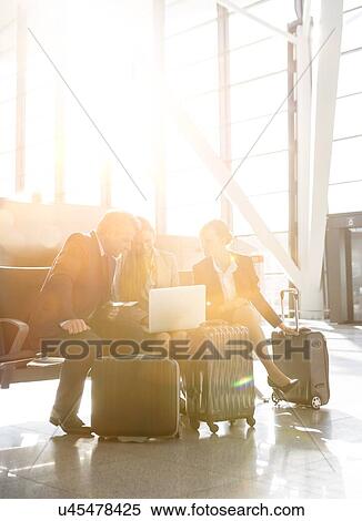 Stock Photography - Business people working while waiting for boarding in the airport. Fotosearch
