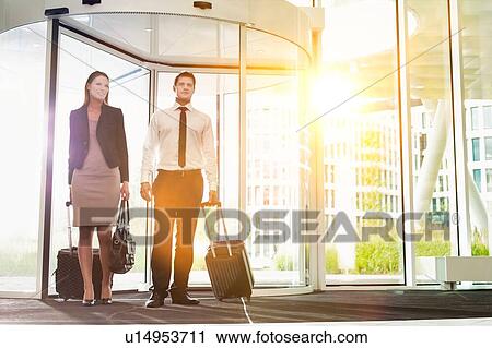 Stock Image - Businessman and businesswoman attending business conference in a hotel. Fotosearch