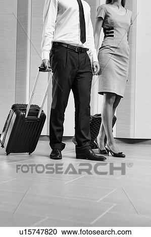 Stock Image - Businessman and businesswoman attending business conference in a hotel. Fotosearch