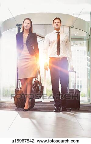 Stock Image - Businessman and businesswoman attending business conference in a hotel. Fotosearch