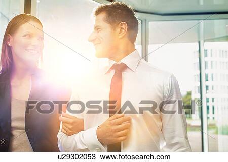 Stock Image - Businessman and businesswoman attending business conference in a hotel. Fotosearch