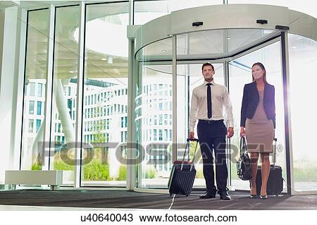 Stock Image - Businessman and businesswoman attending business conference in a hotel. Fotosearch
