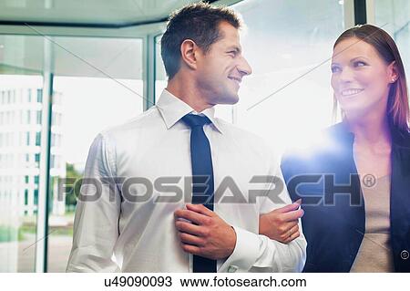 Stock Image - Businessman and businesswoman attending business conference in a hotel. Fotosearch