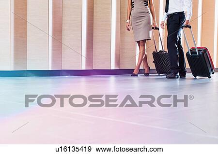 Stock Photo - Businessman and businesswoman attending business conference in a hotel. Fotosearch