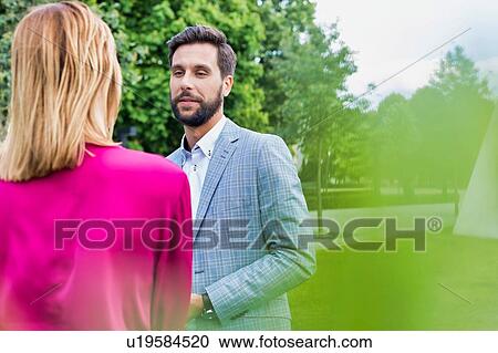 Businessman discussing plans with businesswoman on meeting outdoor View Large Photo Image Stock Image - Businessman discussing plans with businesswoman on meeting outdoor. Fotosearch