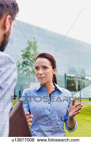 Stock Photo - Businessman discussing plans with businesswoman on meeting outdoor. Fotosearch