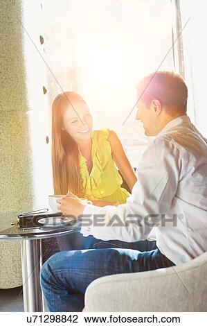 Businessman sitting while discussing plans with business partner in coffee shop View Large Photo Image Stock Image - Businessman sitting while discussing plans with business partner in coffee shop. Fotosearch