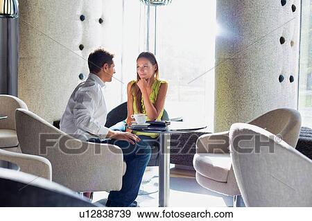 Businessman sitting while discussing plans with business partner in coffee shop View Large Photo Image Stock Photo - Businessman sitting while discussing plans with business partner in coffee shop. Fotosearch