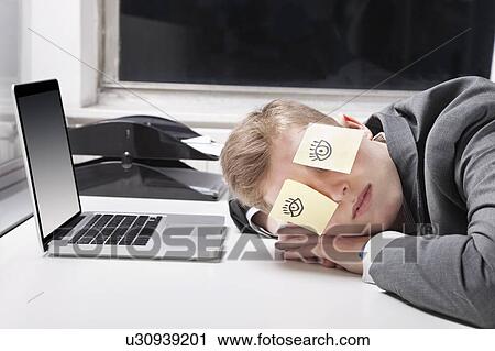 Businessman sleeping with sticky notes on eyes at desk in office View Large Photo Image Stock Image - Businessman sleeping with sticky notes on eyes at desk in office. Fotosearch