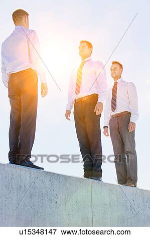Stock Photo - Businessman standing in office rooftop. Fotosearch