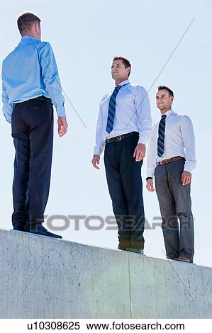 Stock Photography - Businessman standing in office rooftop. Fotosearch