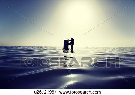 Businessman Standing in the Ocean Searching Through a Filing Cabinet View Large Photo Image Stock Photo - Businessman Standing in the Ocean Searching Through a Filing Cabinet. Fotosearch