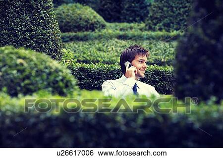 Stock Photograph - Businessman Talking on Cell Phone in Garden. Fotosearch