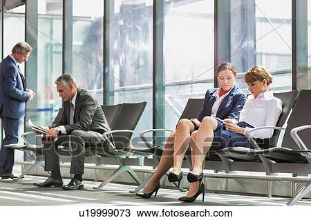 Businesss people sitting while waiting for boarding in airport View Large Photo Image Stock Image - Businesss people sitting while waiting for boarding in airport . Fotosearch