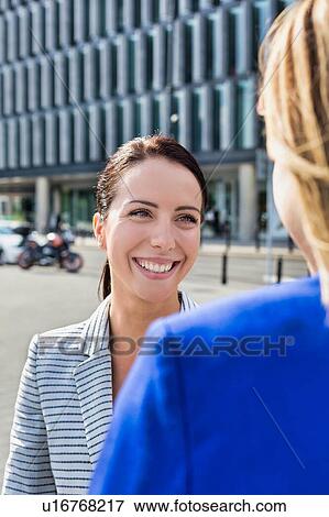 Businesswomen walking while talking outside office building View Large Photo Image Stock Photo - Businesswomen walking while talking outside office building. Fotosearch