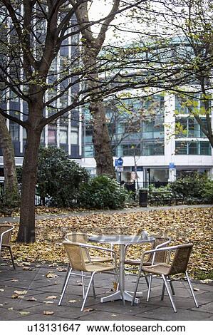 Stock Photo - Chairs and coffee table with autumnal leaves in background. Fotosearch