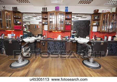 Stock Image - Chairs and wall mirrors in salon. Fotosearch