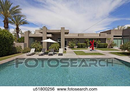 Stock Photograph - Chaise lounge at poolside in luxurious mansion. Fotosearch