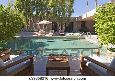 Stock Photograph - Chaise lounge at poolside in manor house. Fotosearch