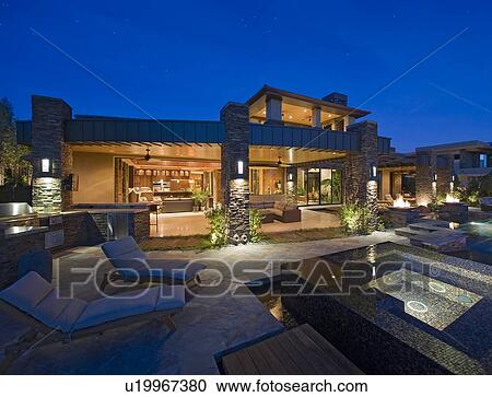 Stock Image - Chaise lounge near hot tub in front of luxury villa. Fotosearch