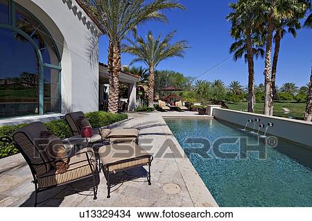Picture - Chaise lounges at poolside in luxury villa. Fotosearch