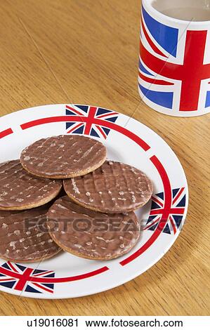 Stock Image - Chocolate biscuits on plate with British coffee mug. Fotosearch