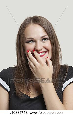 Close-up of a beautiful woman smiling while thinking over gray background View Large Photo Image Stock Image - Close-up of a beautiful woman smiling while thinking over gray background. Fotosearch