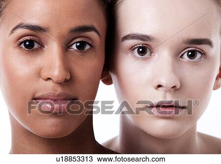 Stock Image - Close up of black and white female faces together. Fotosearch