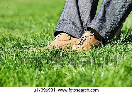 Stock Image - Close up of businessman foot on the grass . Fotosearch