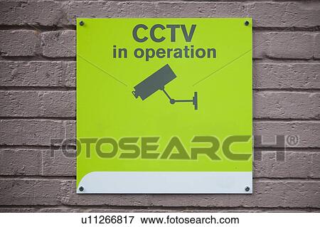 Stock Photo - Close-up of 'CCTV in operation' sign on wall. Fotosearch