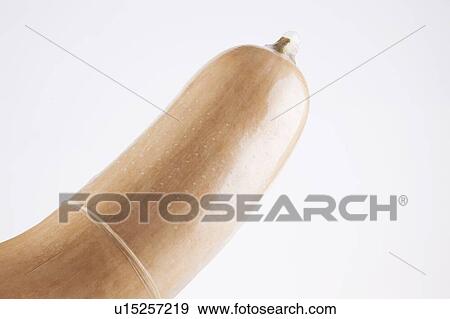 Stock Photo - Close-up of condom on butternut pumpkin over white background. Fotosearch