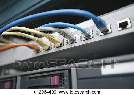 Stock Photo - Close-up of data cable plug connected to servers in computer lab. Fotosearch